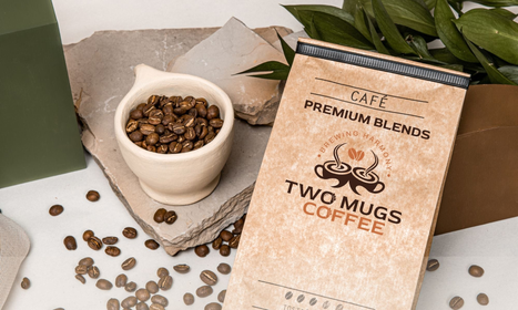 Two ceramic coffee mugs on a soft cloth background, glowing with warm light — evoking richness, comfort, and a shared moment.